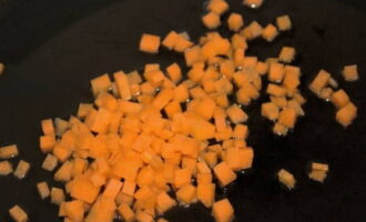 Ставим сковородку на плиту и прогреваем ее вместе с растительным маслом. Подрумяниваем на нем морковку около 3 минут до слабого румянца.