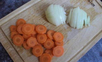Очищаем и ополаскиваем овощи, режем морковь кольцами, а лук – полукольцами. Разогреваем подсолнечное масло и пассеруем до мягкости и светло-коричневого оттенка.