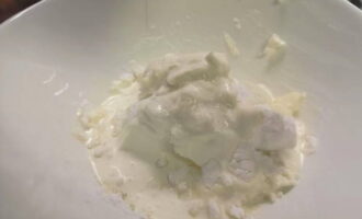 Затем добавьте к сыру 100 грамм сахарной пудры и 100 миллилитров холодных сливок.