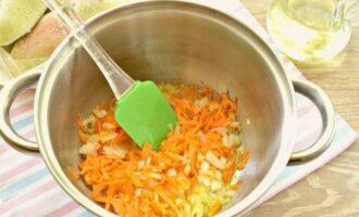 В кастрюлю с толстым дном вливаем растительное масло и прогреваем его. Обжариваем на нем лук с морковью около 3 минут.