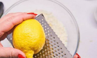 С половины лимона снимите цедру при помощи мелкой терки.