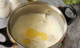 В сливки выкладываем кусочки плавленого сыра и вливаем растительное масло. Перемешиваем.