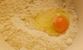 В полученную массу разбиваем куриное яйцо. Два яйца оставляем для крема.