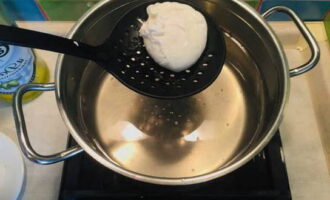 При помощи шумовки извлеките готовое яйцо пашот из воды и выложите его на бумажное полотенце, чтобы оно впитало лишнюю жидкость.