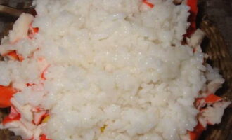 Дополняем продукты в салатнике отварным рисом. Его важно не переварить, чтобы продукт оставался рассыпчатым и подходящим для салата. Для этого рис можно поварить около 15 минут, после оставить под крышкой на выключенной плите.