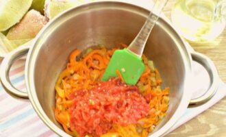 Помидоры натираем на терке. Так мы отделим томатную массу от кожицы. Овощное пюре отправляем в кастрюлю, хорошо все перемешиваем и тушим 5 минут.