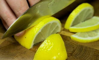Как приготовить сочную горбушу в фольге в духовке? Лимоны необходимо тщательно вымыть с горячей водой, а лучше ополоснуть их кипятком, чтобы смыть с поверхности кожуры всю химическую обработку. Один лимон разрежьте пополам вдоль, затем каждую половинку нарежьте не слишком тонкими дольками. Второй лимон разрежьте пополам поперек.