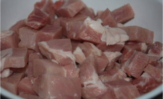Как приготовить рассыпчатый плов из свинины в казане на плите? Килограмм мяса ополаскиваем и обсушиваем, режем на ломтики со сторонами около трех сантиметров.