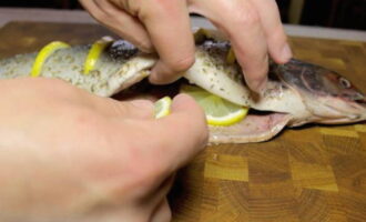 В брюшко каждой рыбы положите оставшиеся дольки лимона, а также по одной веточке свежего розмарина.