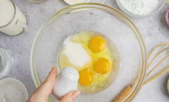 Яйца моем и насухо вытираем. Разбиваем их в объемную чашу. Кладем соль и сахарный песок.