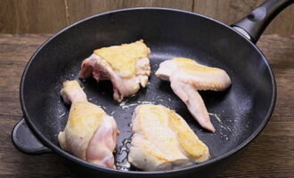 Берем сковороду с толстым дном и очень хорошо разогреваем, не добавляя масла. Порциями выкладываем куски курицы. Подрумяниваем с двух сторон. Таким образом обжариваем всю курицу.