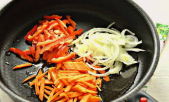 Перец разрежьте пополам, очистите половинки от белых перегородок и семян. Нарежьте морковку и половинки перца соломкой, луковицу нарежьте полукольцами или перьями. На предварительно разогретую сковородку влейте немного подсолнечного масла и выложите овощную нарезку. Начните обжаривать овощи, помешивая лопаткой.