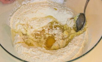 Добавляем в сухую смесь куриное яйцо, соль и вливаем растительное масло (выбираем без запаха). Активно размешиваем продукты.