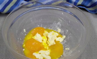 Аккуратно отделяем яичные желтки от белков. Для этого можно проделать в яйцах отверстия, аккуратно слить белок, а дальше извлечь желток из скорлупы. Яичные желтки отправляем в посуду с размягченным сливочным маслом.