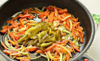 По ходу дела нарежьте соломкой соленые огурцы и добавьте их на сковороду к овощам. Продолжайте жарить овощи в течение 7 минут на умеренном огне.