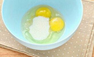 Выбираем глубокую емкость для вымешивания теста. В подходящую миску разбиваем куриные яйца, всыпаем сахарный песок и немного соли. Если ваши яйца слишком мелкие, то можно добавить три штуки вместо двух.