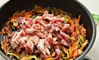 Свинину обмойте и нарежьте ее продолговатыми брусками. Когда овощи станут мягкими, выложите на сковороду мясо, перемешайте.
