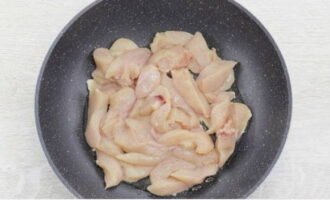 Куриное мясо нарежьте брусочками и обжарьте на сковороде, на разогретом растительном масле, на среднем огне и до изменения цвета на белый.
