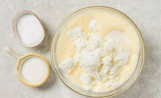 К взбитой яичной массе кладем 400 граммов 5% творога, 2 столовые ложки сахарного песка и щепотку соли.