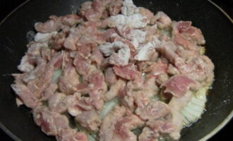 Дополняем лук свининой в мучной панировке. Готовим продукты пять минут, периодически переворачивая кусочки мяса.