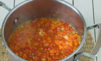 В половине стакана теплой воды размешиваем томатную пасту и все это переливаем в кастрюлю к овощам. Доводим массу до кипения.