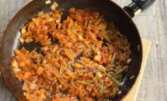 Через 5 минут откройте крышку, добавьте на сковороду томатную пасту и жарьте лук с огурцами 3-4 минуты. После сразу выложите содержимое сковороды в кастрюлю с бульоном.