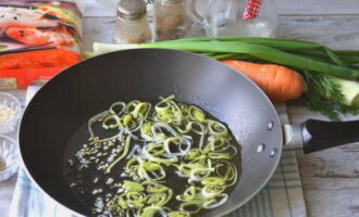 Прогреваем сковородку с растительным маслом и две минуты жарим на нем лук-порей с чесноком.