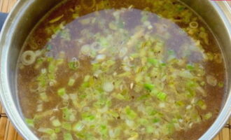 Обжаренные компоненты заливаем бульоном, мисо пастой, соевым соусом и еще одной столовой ложкой кунжутного масла.