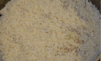 Затем распределяем слой тщательно промытого риса и заливаем водой (400-450 миллилитров).