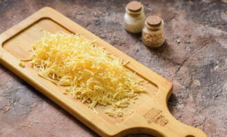 80 грамм твердого сыра натрите на мелкой терке. И уже можно включать духовку, чтобы она грелась.
